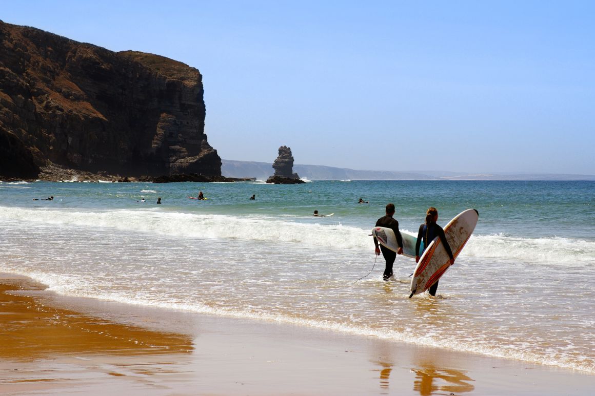 Surfaři na pláži Arrifana v Algarve, Portugalsko