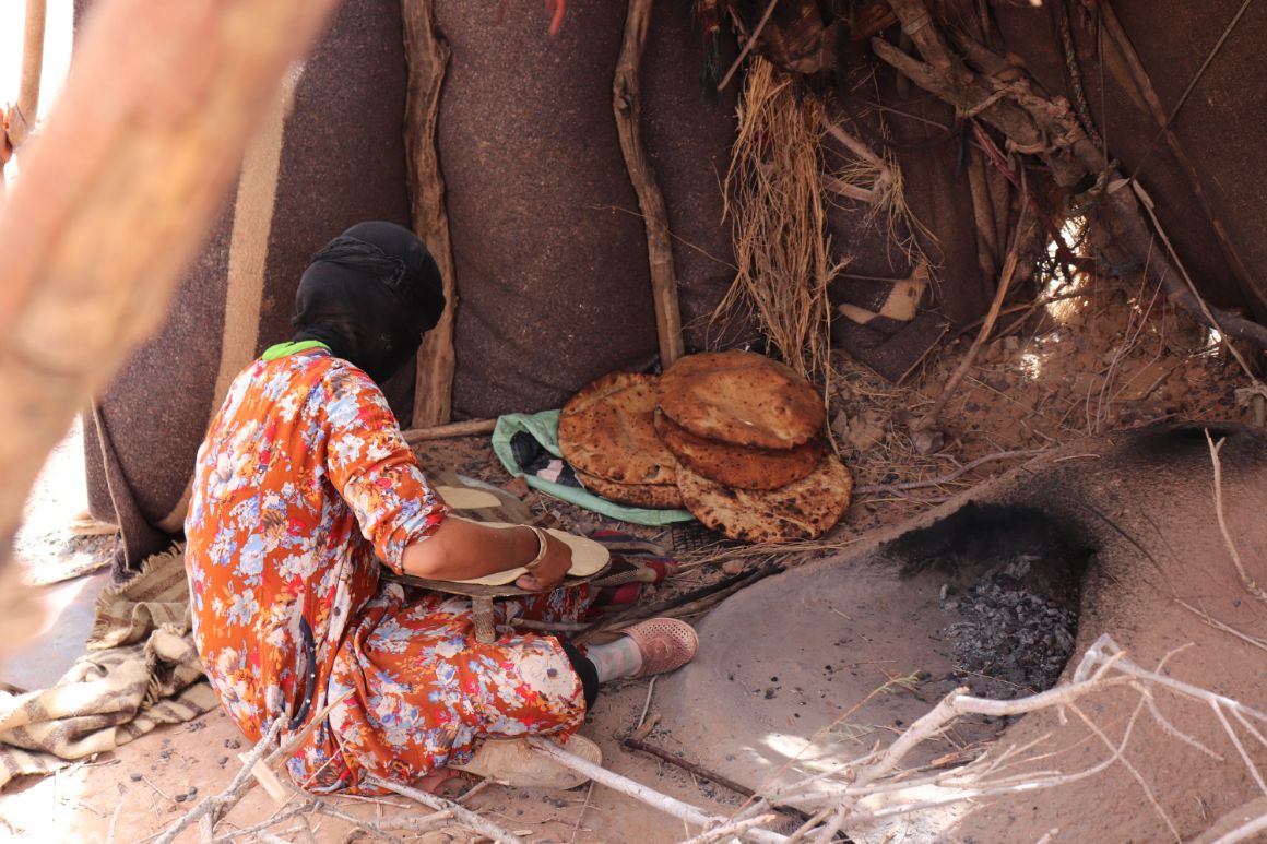 Beduínská žena peče chléb „khob“ v tradiční peci